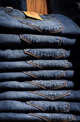 a shelf stocked with jeans