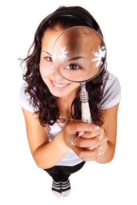 a girl holding a magnifying glass