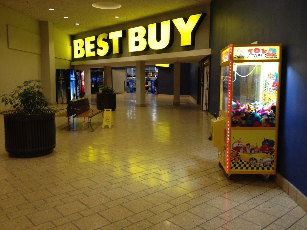 The Best Buy entrance sign inside the Holyoke Mall in Holyoke, Massachusetts, with a toy claw machine in the foreground
