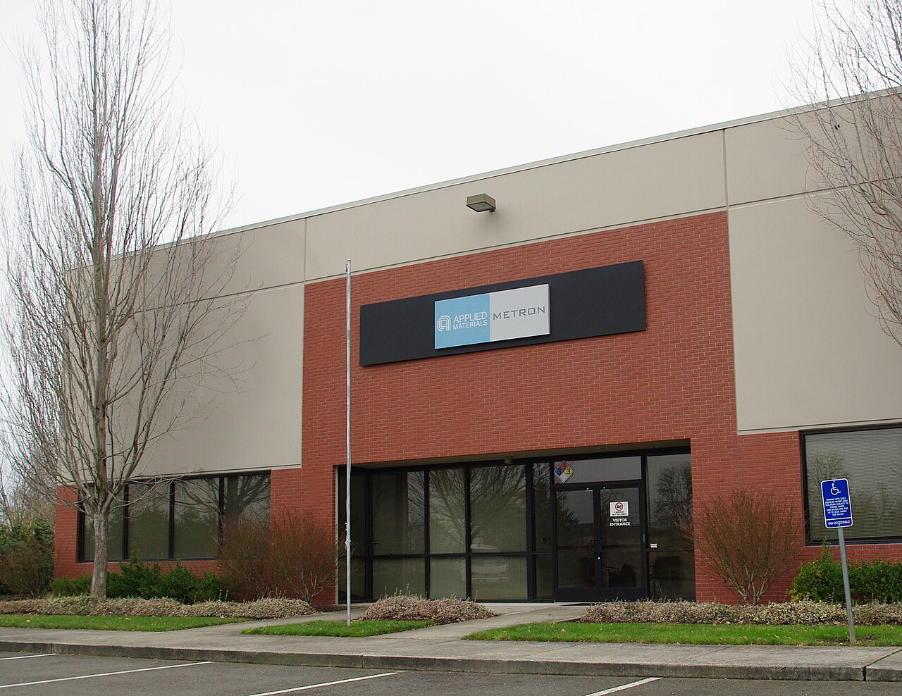 Entrance of an Applied Materials office building in Hillsboro, Oregon, with the Applied Materials Metron sign above the door.
