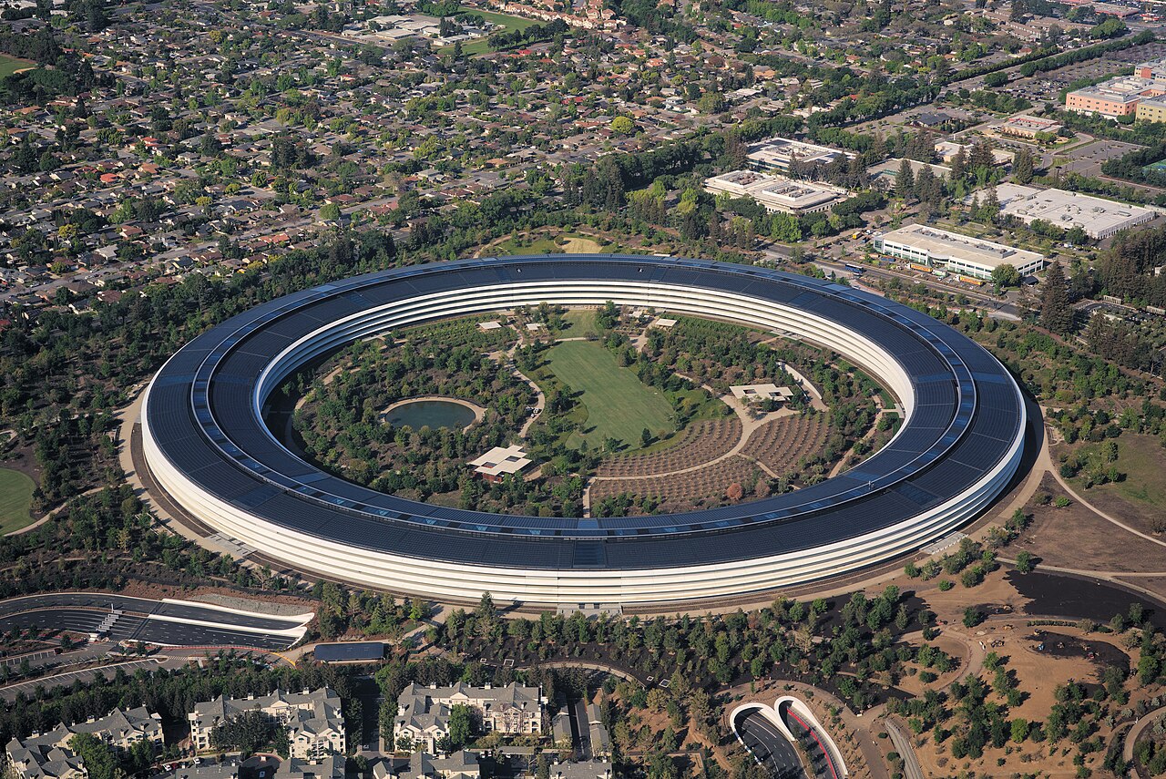 Aerial view of Apple Park, the ring-shaped Apple campus in Cupertino, California, surrounded by trees and neighborhoods