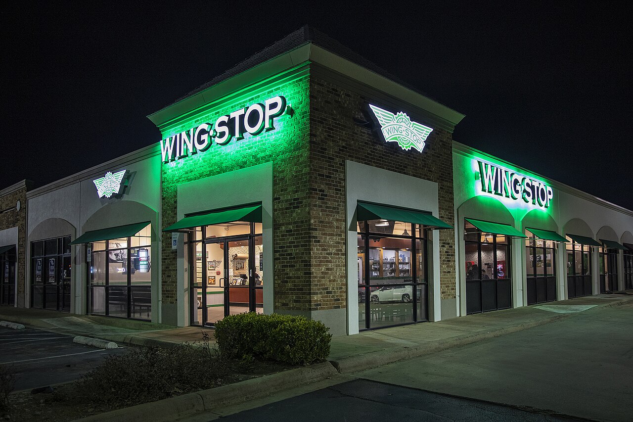 A Wingstop restaurant in Irving, Texas, lit at night with green signs